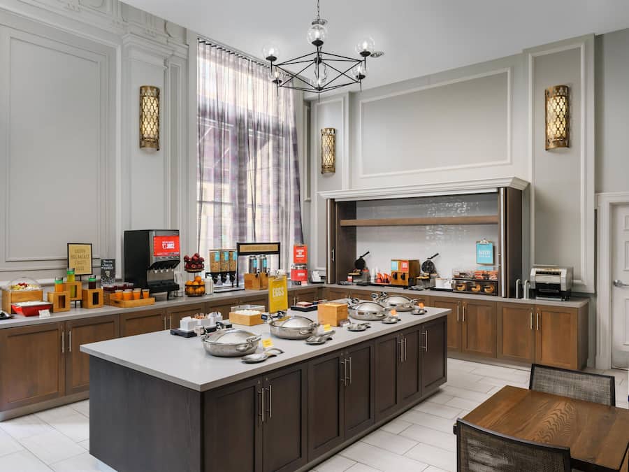 A modern kitchen with a central island, built-in appliances, and a breakfast bar.