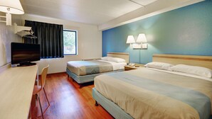 A hotel room with two beds, a desk with a chair, a television, and a window with curtains. - Motel 6 Newport, RI (Newport)