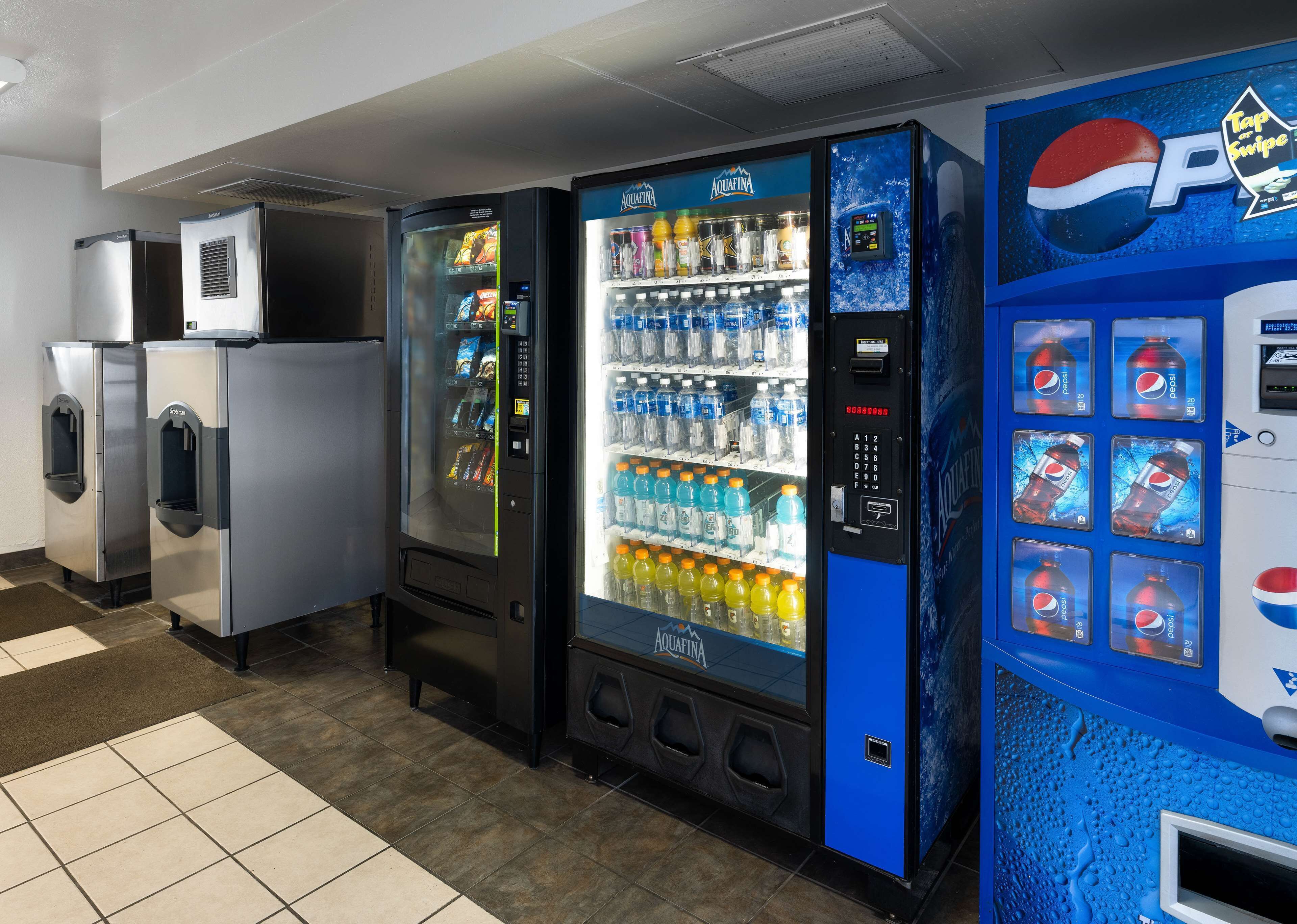 Una hilera de máquinas expendedoras, incluyendo un dispensador de Pepsi, en un entorno comercial.