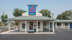 Un motel con un letrero con el número '6' y un letrero de 'bienvenida' sobre la entrada.