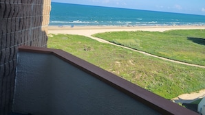 Un balcón con vista a la playa y el océano.