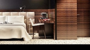 Une chambre à coucher moderne avec un grand lit, un bureau et une armoire.