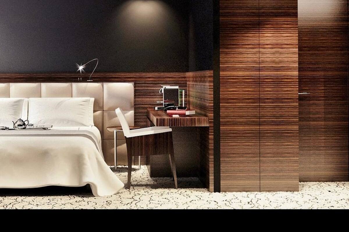 Une chambre à coucher moderne avec un grand lit, un bureau et une armoire.