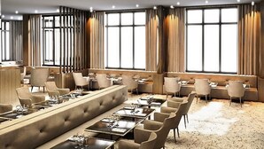 A modern hotel lobby with a long bar, seating areas, and large windows. - Howard Hôtel Paris Orly Aeroport (Paray-Vieille-Poste)