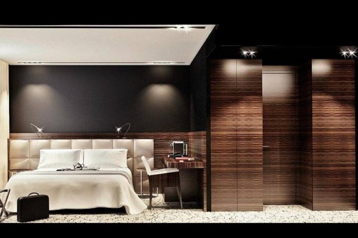 Une chambre moderne avec un grand lit, des tables de chevet, un bureau et une armoire.