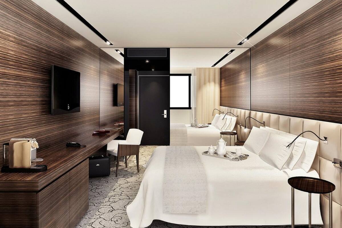 Une chambre d’hôtel moderne équipée d’un grand lit, d’un bureau avec une chaise, d’une télévision et d’une armoire.