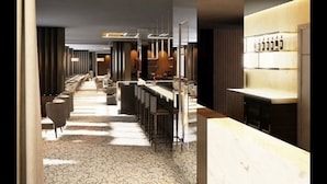 Un hall d’hôtel moderne avec un long comptoir d’accueil, un bar et un espace salon.