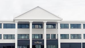 Un bâtiment moderne doté d’une entrée imposante, sur laquelle on peut lire l’inscription « HOWARD ».