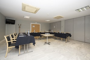 A conference room with a long table, chairs, a projector, and a television on the wall. - Holiday Inn Express Barcelona-Montmeló by IHG (Granollers)