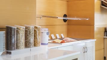 Un bufé de desayuno con diversos alimentos y recipientes.
