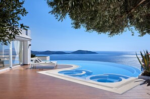 Zona de piscina con vistas al mar y a las montañas.