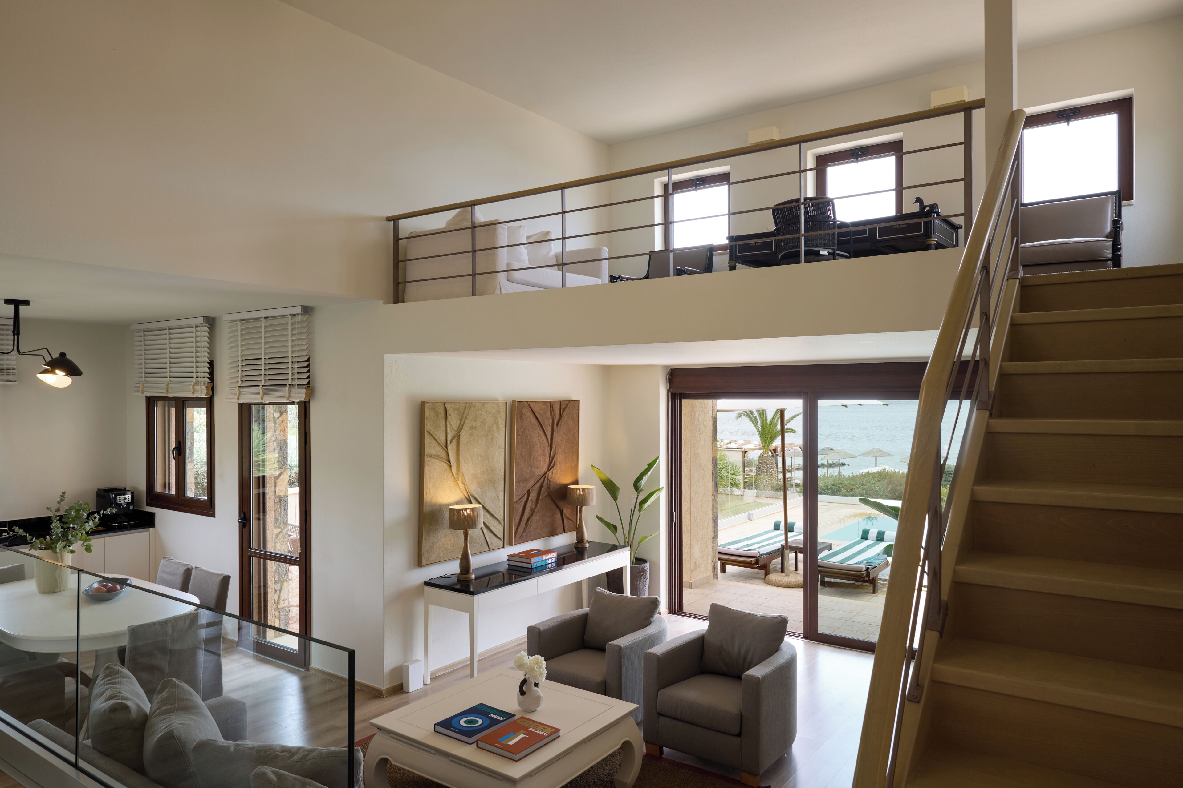 Un salón espacioso con balcón, comedor y vista al mar.