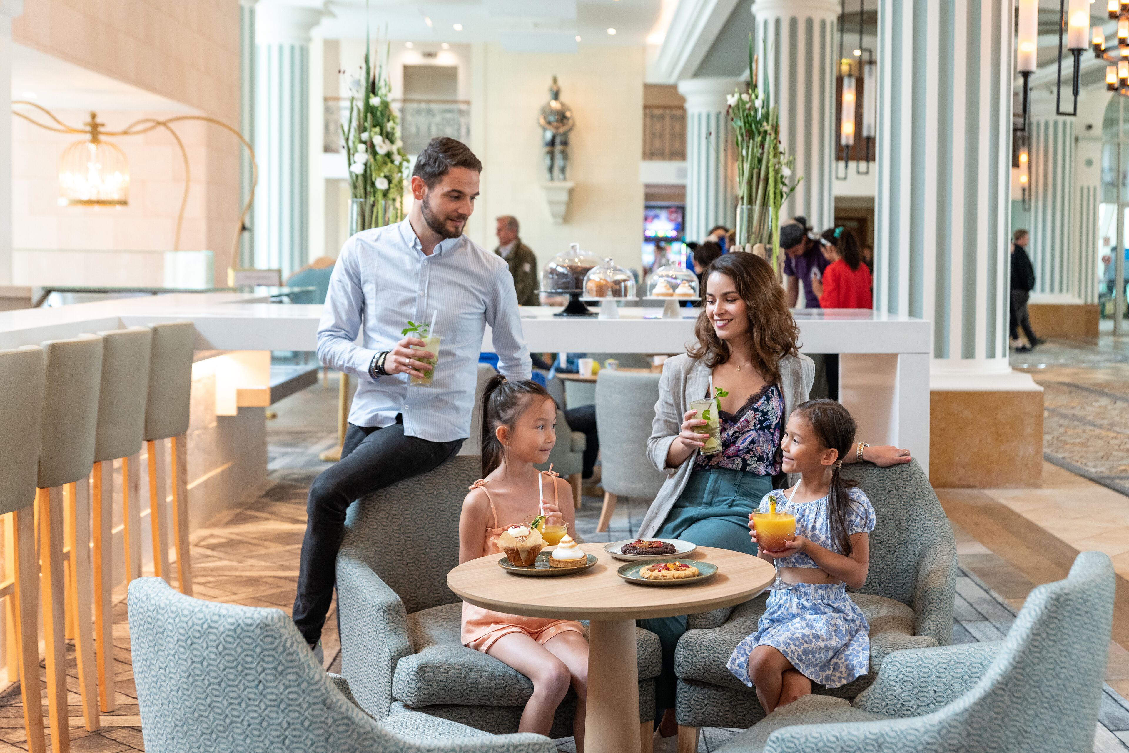 A family dining at a modern indoor restaurant with a bar area in the background.
