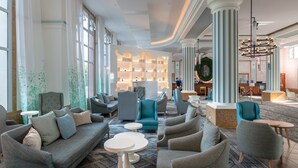 A lobby with seating areas, a reception desk, and a large chandelier.