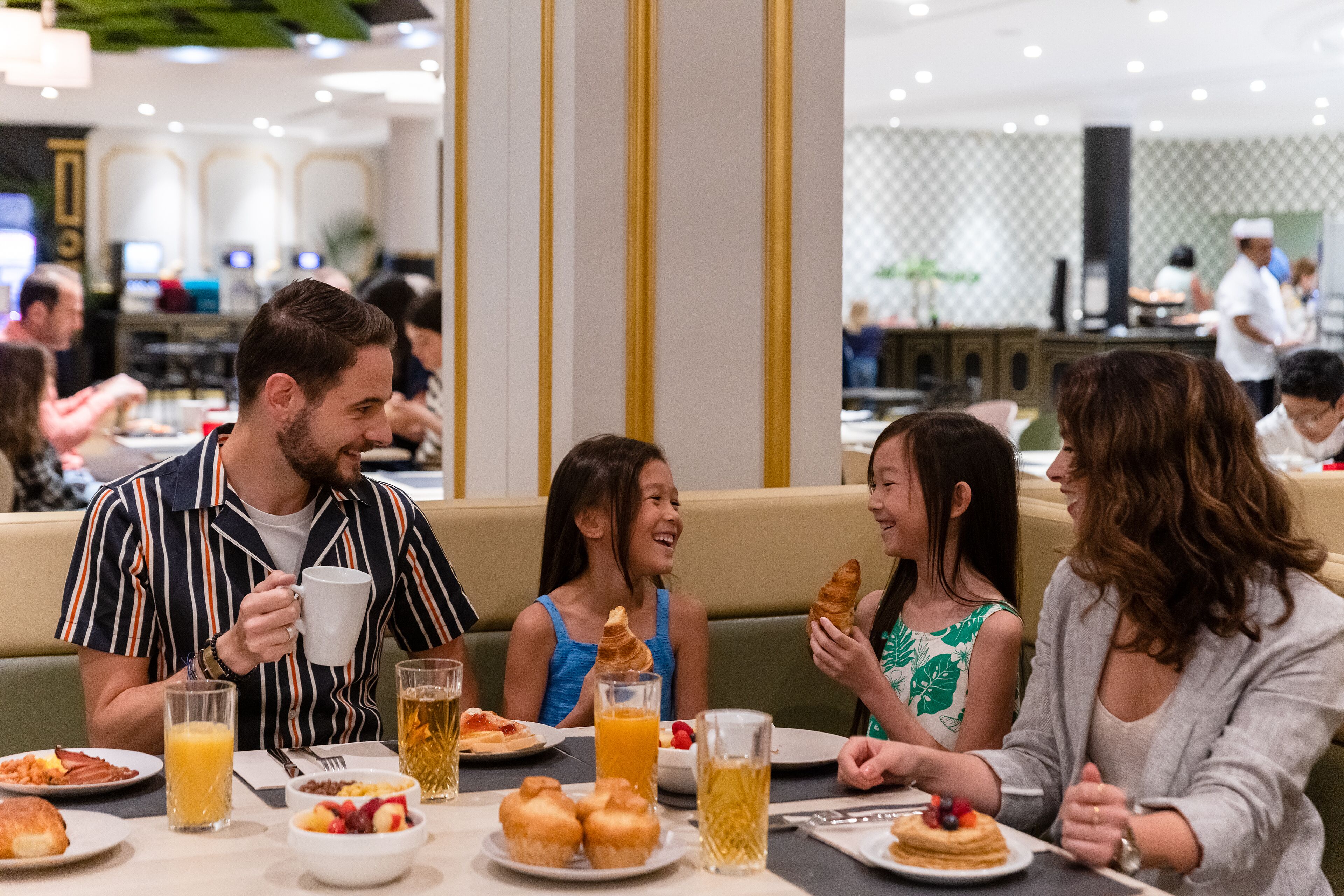 Un grupo de personas cenando en un restaurante con una variedad de platos y bebidas sobre la mesa.