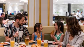 Un grupo de personas cenando en un restaurante con una variedad de platos y bebidas sobre la mesa.