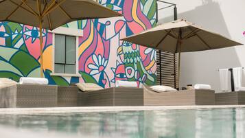 Alberca al aire libre y camastros