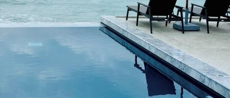 Alberca al aire libre, sombrillas en la alberca y camastros