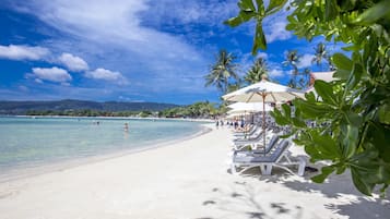Am Strand, weißer Sandstrand, Sonnenschirme