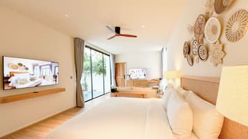 A modern hotel room with a large bed, a television mounted on the wall, a ceiling fan, and a view of the outdoors through the sliding glass door.