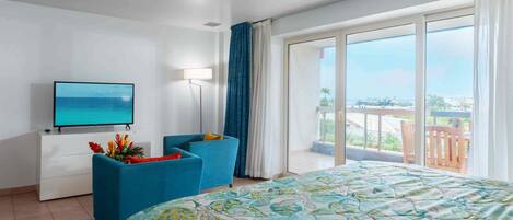 A hotel room with a bed, a TV, a desk, and a chair.