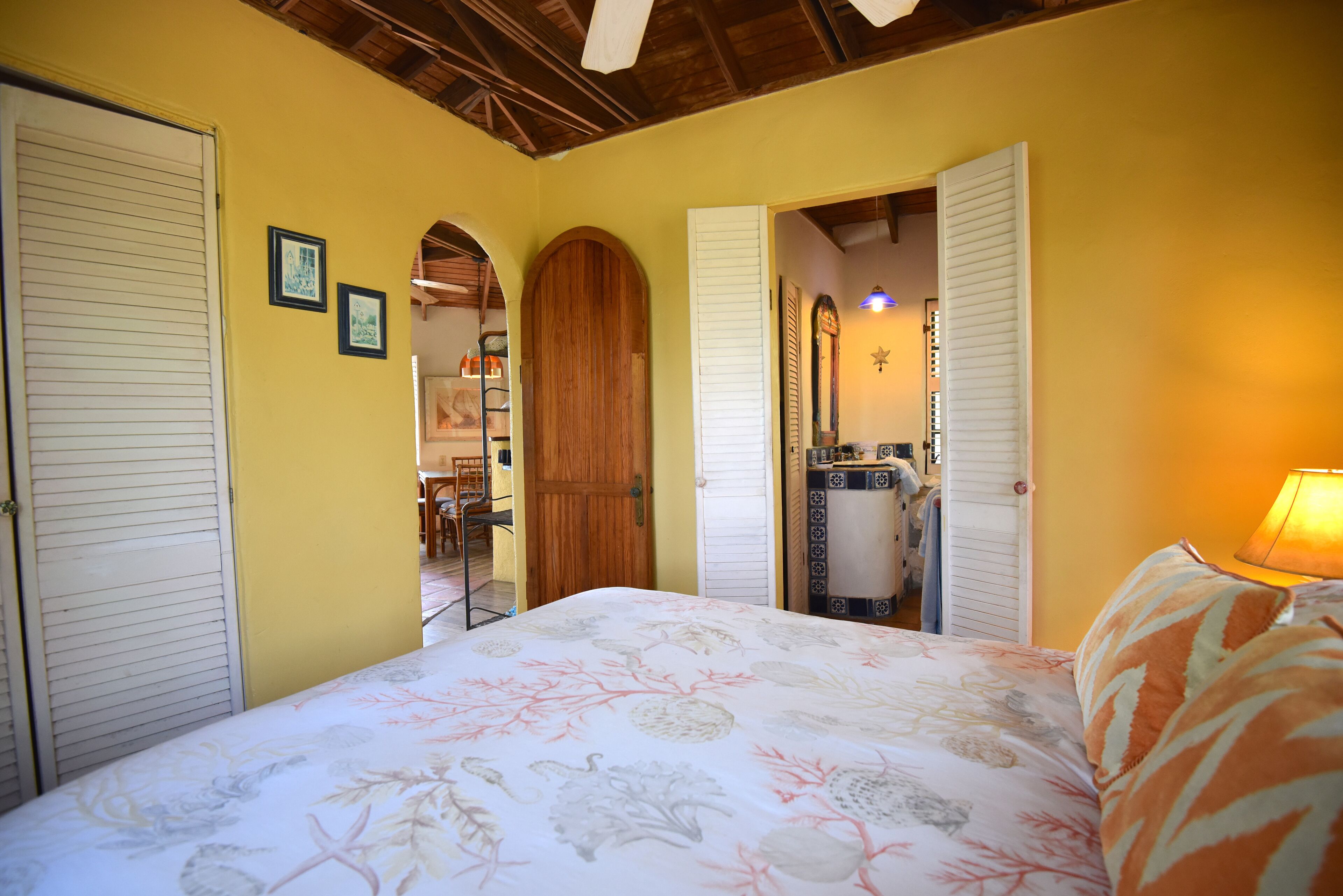A bedroom with a bed, wooden door, and a mirror.