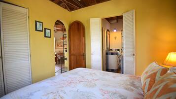 Un dormitorio con cama, puerta de madera y espejo.