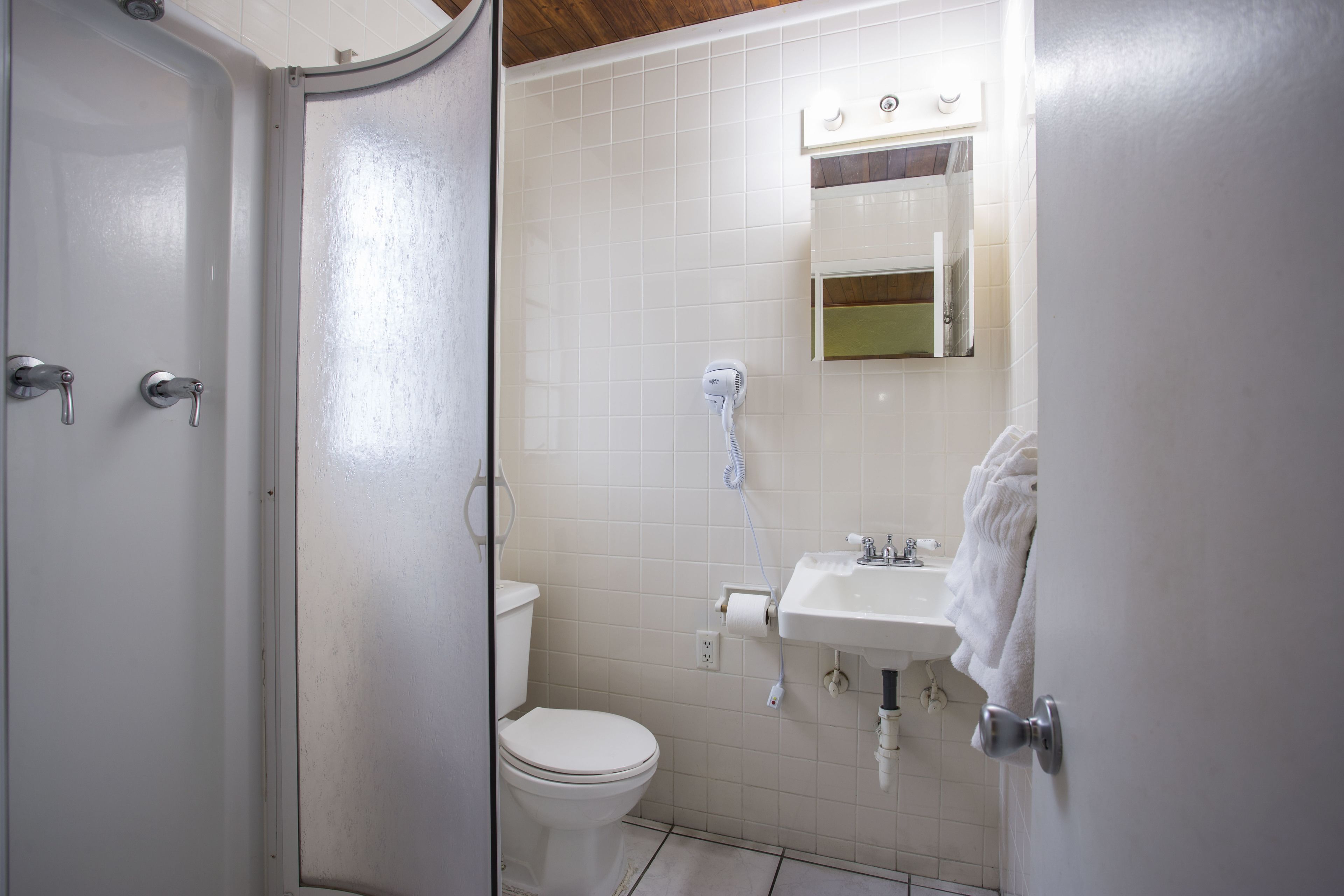 A bathroom with a toilet, sink, and shower.