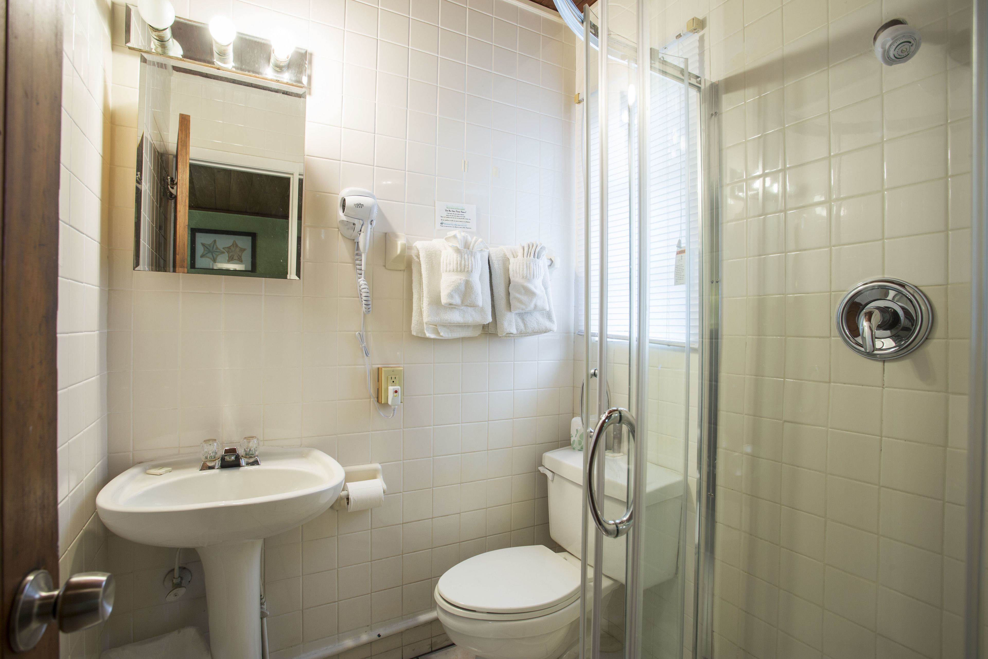 A bathroom with a sink, toilet, and shower.