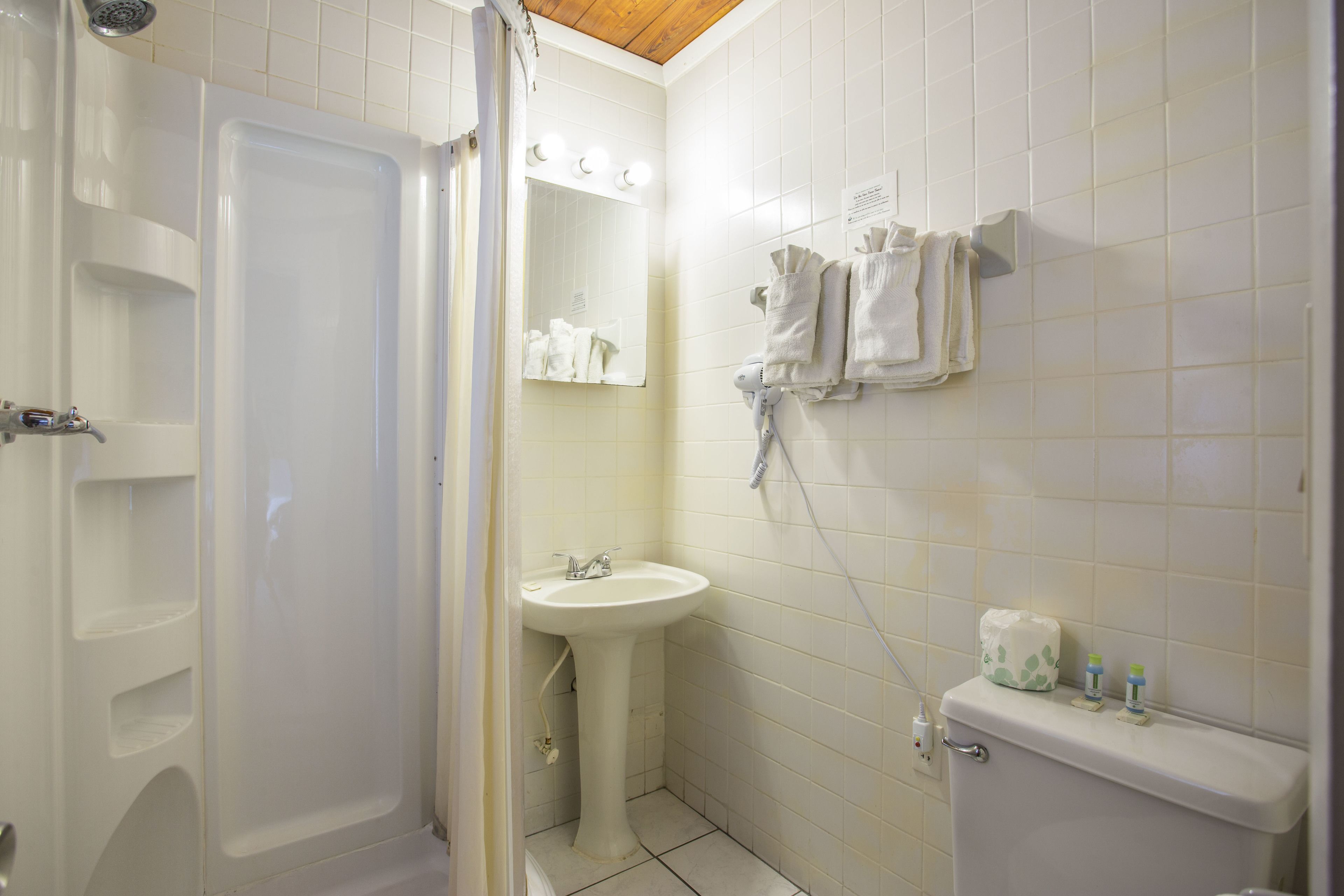 Et badeværelse med badekar, vask og toilet.