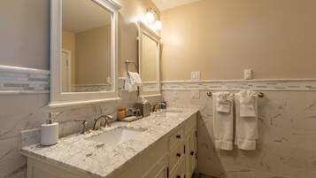 A bathroom with a double sink, a large mirror, and a towel rack.