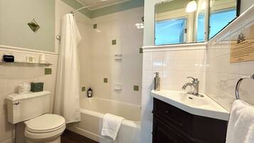 A bathroom with a toilet, a bathtub, a shower, and a sink.