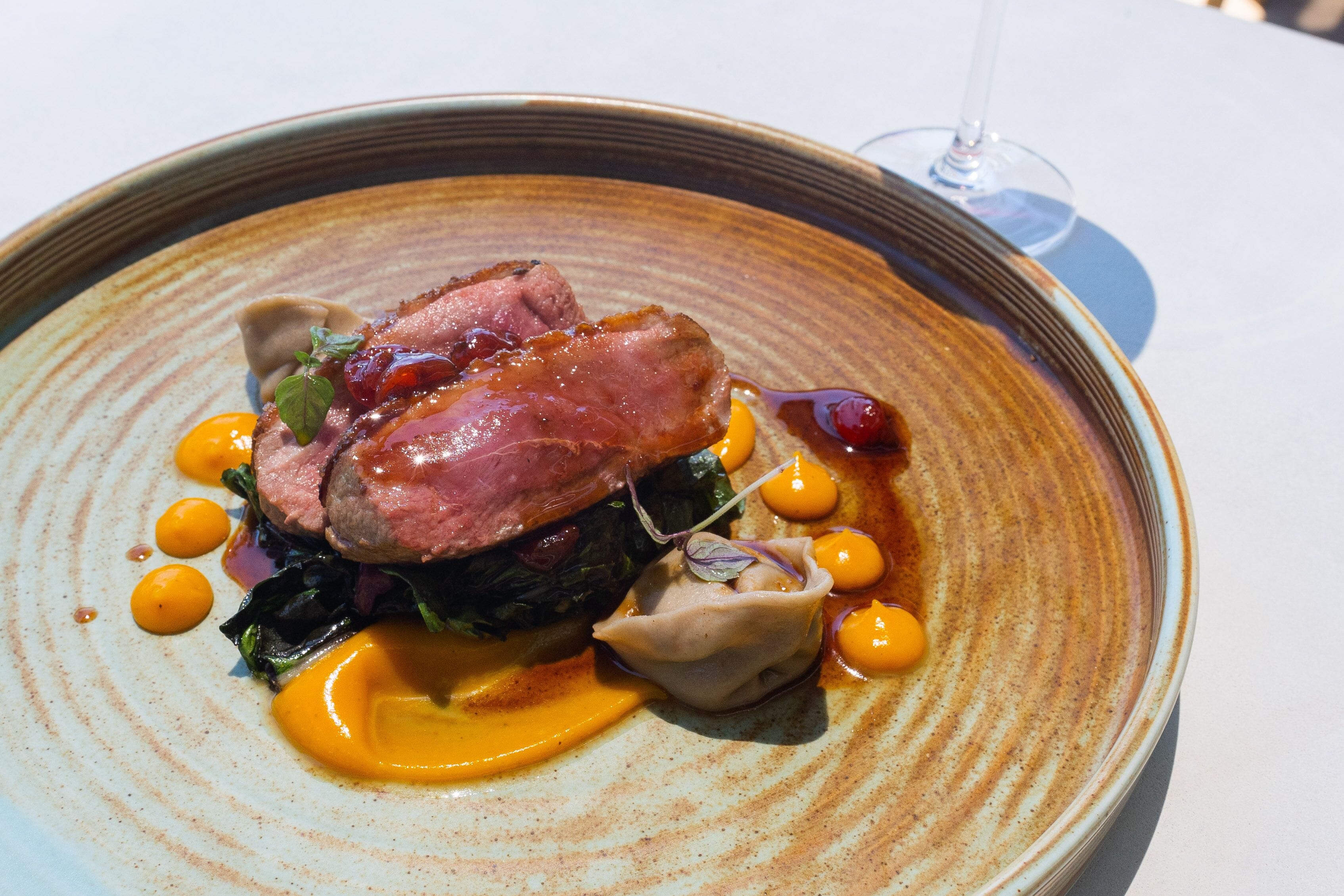 A plate of food with a glass of wine.