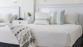 Un dormitorio ordenado con cama, mesitas de noche y una mesilla.
