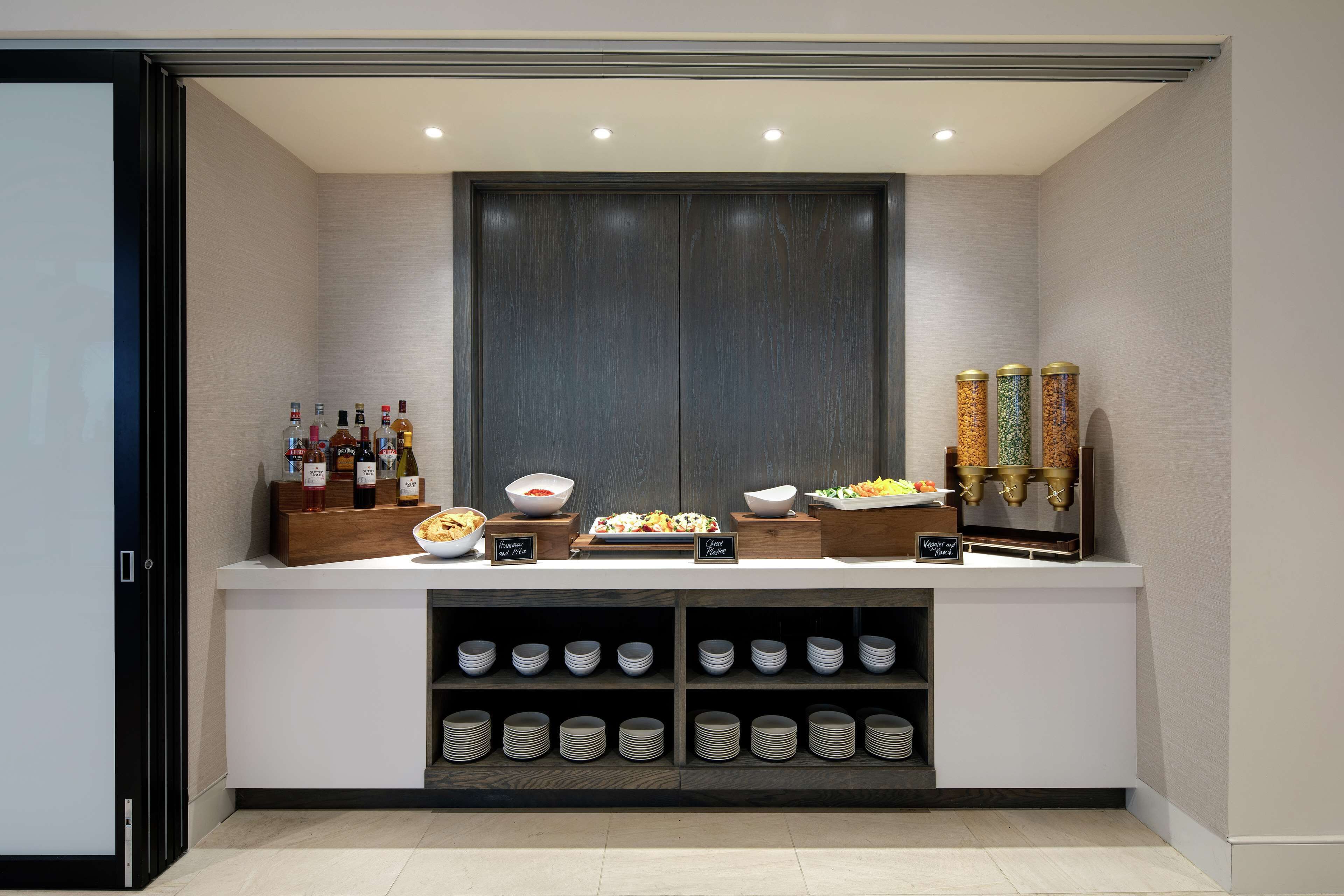 Montaje de buffet con diversos alimentos, salsas y bebidas.