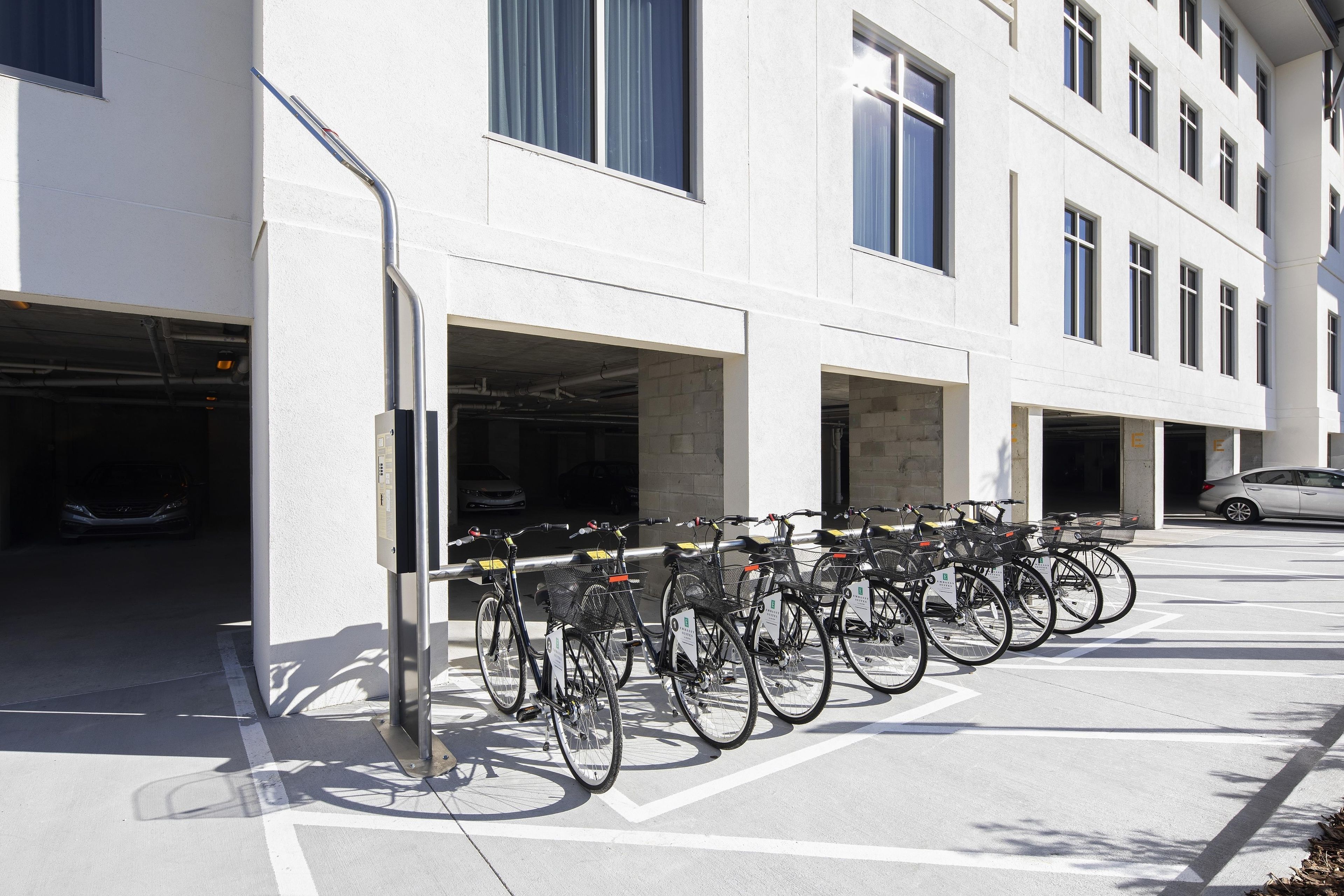 A parking garage with multiple levels, bicycles parked outside, and a car inside.