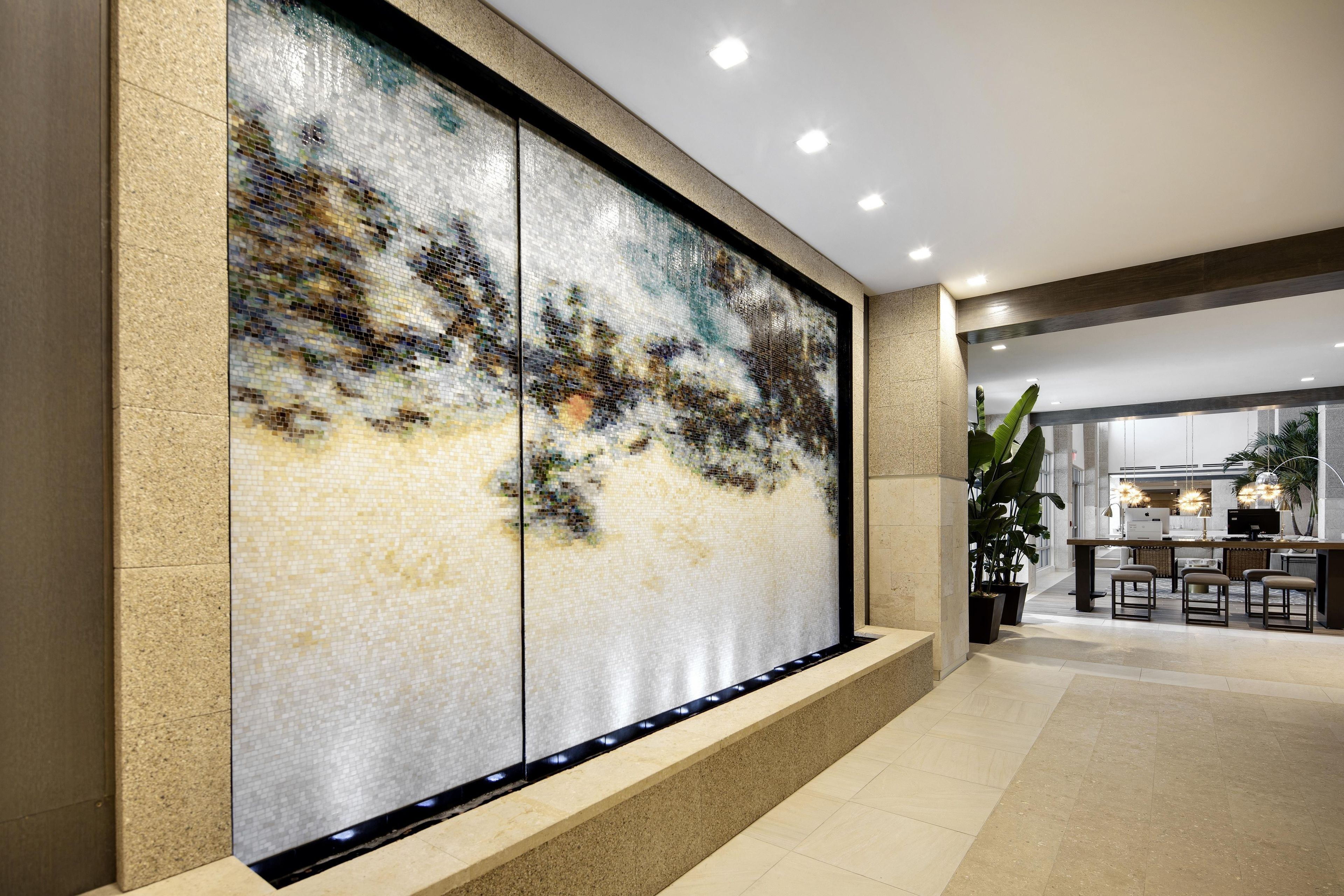 A modern interior with a large mosaic wall, a bar area, and a seating space.