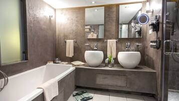 Une salle de bain moderne avec deux grands lavabos, une baignoire et une douche à l’italienne.