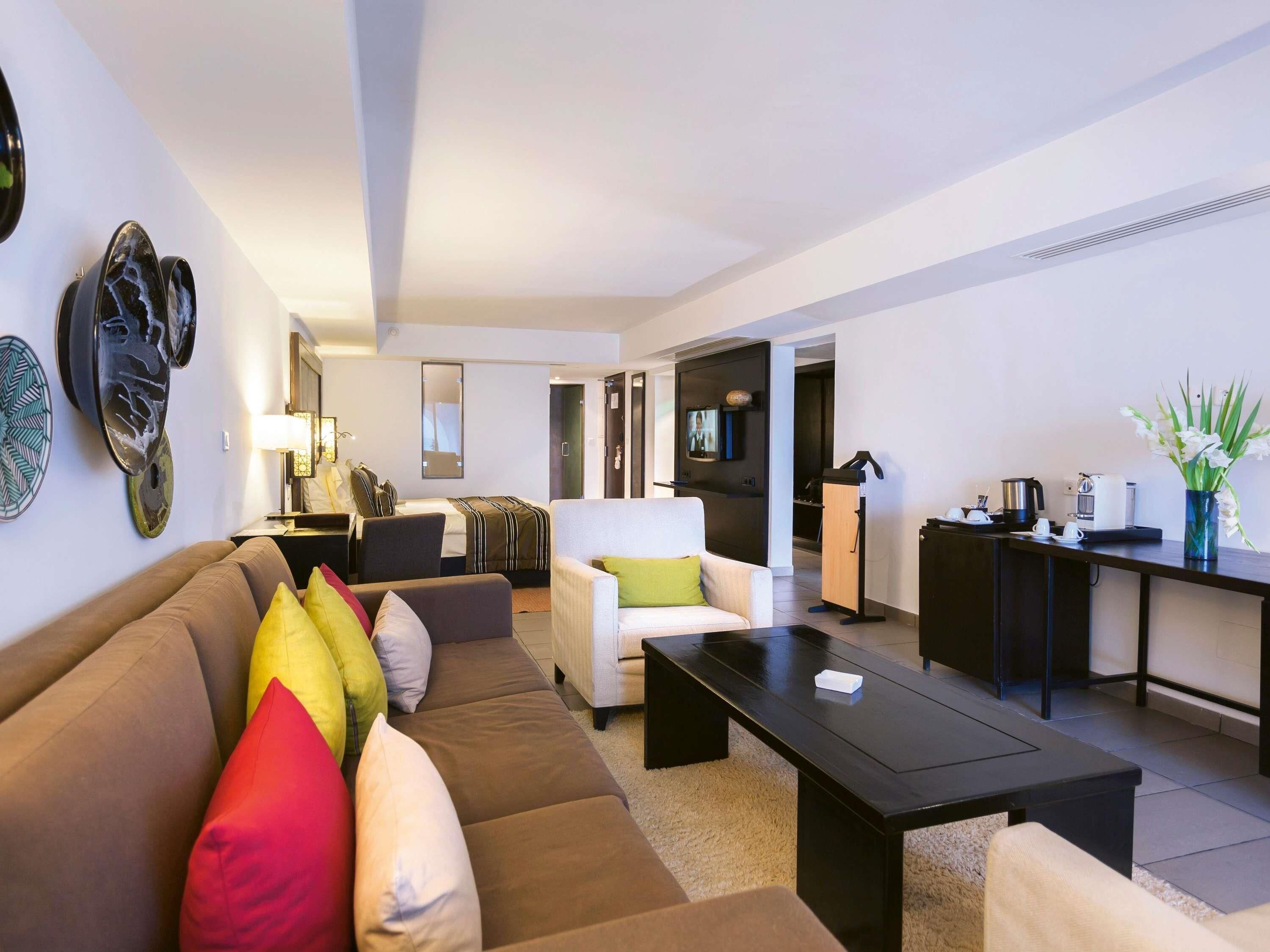 Una sala moderna con sofá, mesa de centro y televisor.