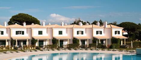 Un hotel con piscina y zona de estar al aire libre.