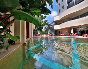 An indoor swimming pool with clear water, surrounded by lounge chairs and potted plants. - Lancaster Tamar Hotel (Hadath)