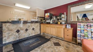 Ein Hotel-Rezeptionsbereich mit Marmorzauber, einer Kaffeemaschine und einem Spiegel.