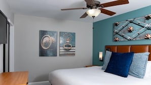 A bedroom with a bed, a ceiling fan, and two wall-mounted artworks. - Club Wyndham Riverside Suites (San Antonio)