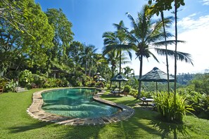 Una piscina al aire libre, tumbonas