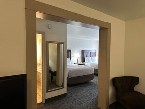 A hotel room with a bed, bedside table, lamp, and a mirror. - Quality Inn & Suites Everett (Everett)