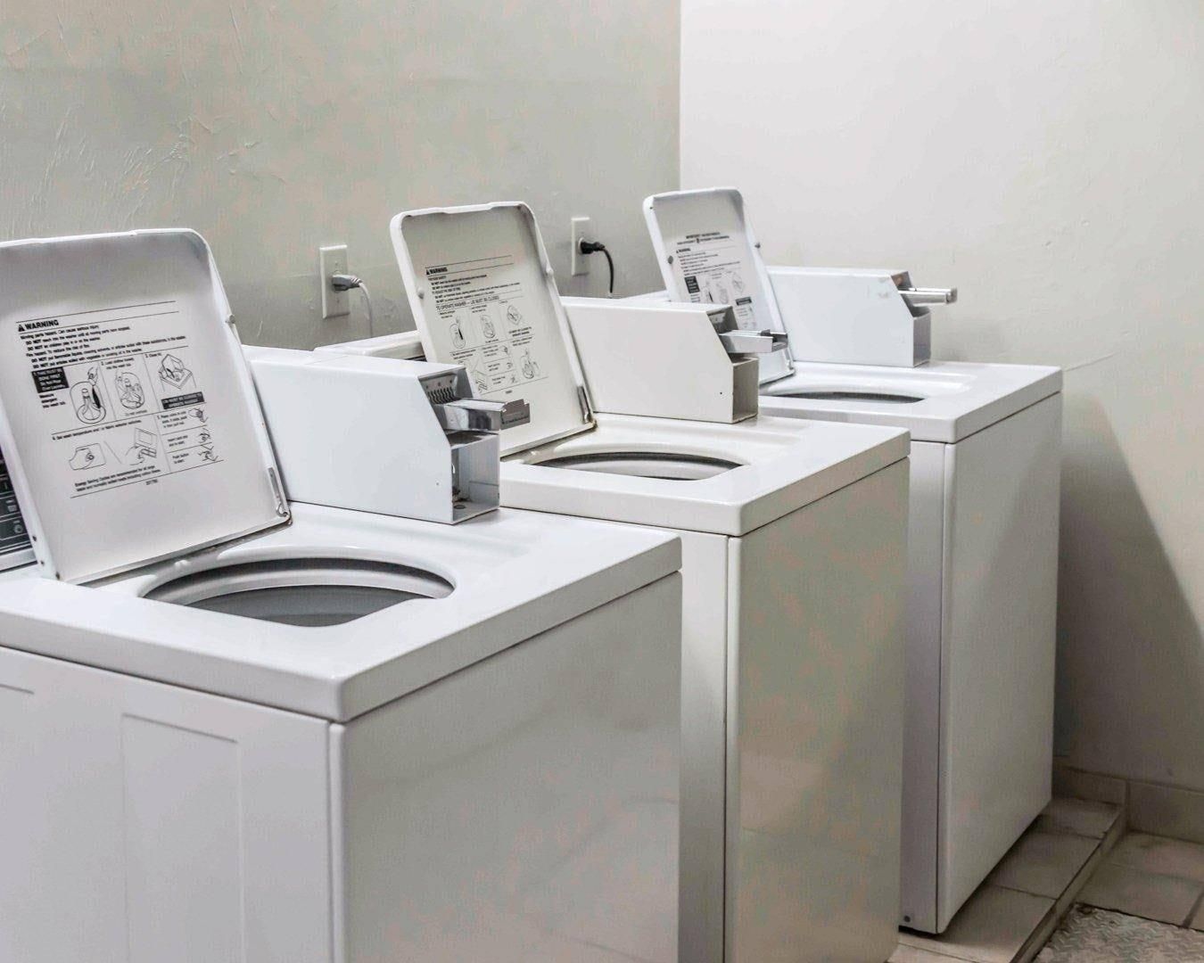 A row of white, modern, wall-mounted toilets with instructions on the front.