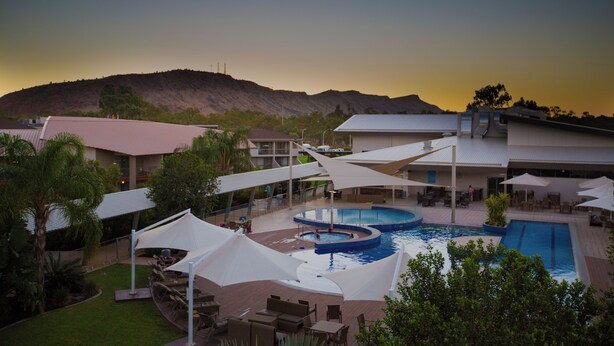 A resort with a pool area, outdoor seating, and a view of a mountain. - Crowne Plaza Alice Springs Lasseters by IHG (Desert Springs)