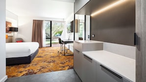 A hotel room with a bed, desk, and kitchenette. - Crowne Plaza Alice Springs Lasseters by IHG (Desert Springs)