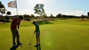 Golfers enjoy a round on the well-manicured course surrounded by trees and shrubs.