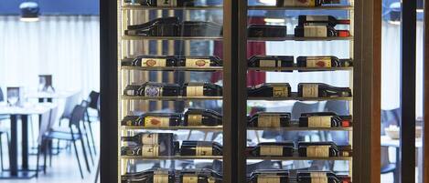 Una alacena para vinos con varias botellas en una habitación bien iluminada.